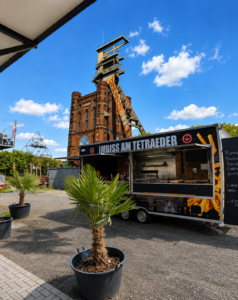 Geöffneter Foodtruck vor einem historischen Förderturm